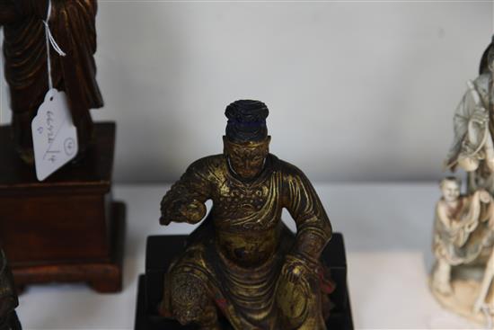 A Chinese gilt lacquered wood seated figure of Guandi, 18th / 19th century, and three other Chinese figures, all with some faults